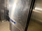 a stainless steel refrigerator in the corner of a kitchen