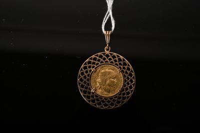 a close up of a gold coin on a white string