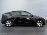 the black tesla model s is parked on the concrete floor