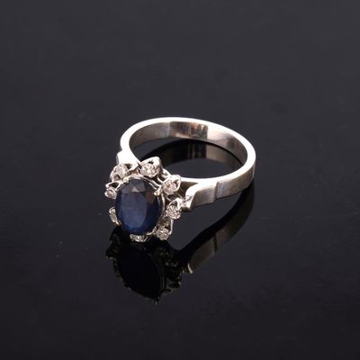 a sapphire and diamond ring on a black surface