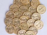 a pile of gold coins sitting on a white surface