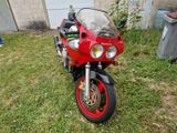 a red motorcycle that is parked in the grass