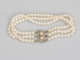 un collier de perles à trois rangs muni d'un fermoir
