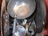 une boîte remplie d'objets en argent posée sur un canapé