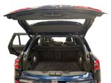 the back end of a blue car with its trunk open