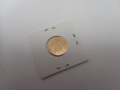 une pièce d'or au milieu d'un morceau de papier carré