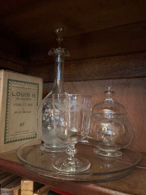 Des bouteilles et des verres sont posés sur une étagère dans une pièce.