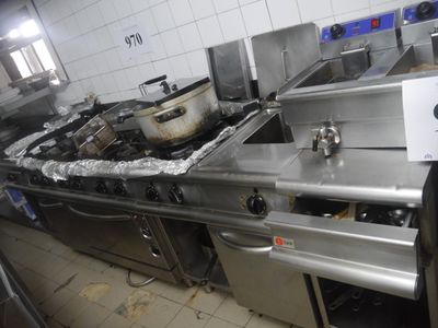 a kitchen with a stove, sink, and a pot on the counter