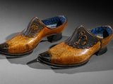 pair of wooden shoes with black and gold decoration on them
