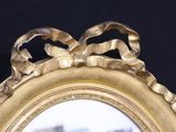 a gold mirror with a bow on it