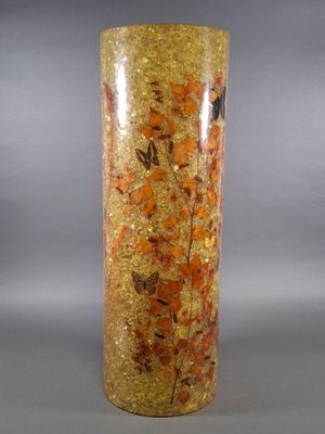 a tall vase with orange and yellow flowers in it
