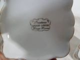 une petite assiette blanche bordée d'une bordure dorée
