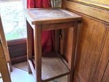 une petite table en bois sur laquelle trône une statuette d'oiseau