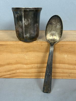 une cuillère et une tasse posées sur une étagère en bois