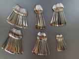 several spoons and forks are arranged in a row on a table