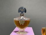 a bottle of perfume sitting on a table next to a glass