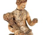 an old statue of a woman sitting on a rock with her hands in the air