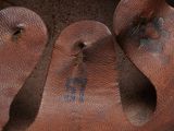 a close up of a brown leather shoe with holes in it
