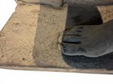a statue of a person ' s feet on a stone slab