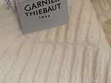 a close up of a white sweater with a label on it