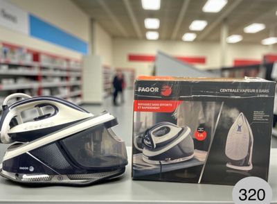 un fer à repasser noir et blanc posé sur une table dans un magasin