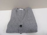 grey cardigan sweater on a white table with a black button