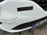 the front of a white car with a sticker on it ' s bumper