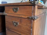 a wooden desk with two drawers and a laptop on it