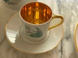a cup and saucer sitting on a marble table