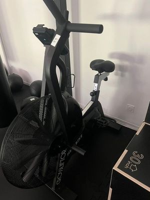un vélo d'appartement noir sur lequel est posé un sac noir