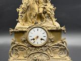 une horloge en or surmontée d'une statue