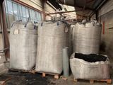 des sacs de charbon de bois posés sur des palettes devant un bâtiment
