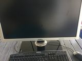 un écran d'ordinateur et un clavier posés sur un bureau