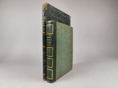 un vieux livre à la couverture verte posé sur une table blanche