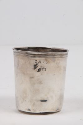 une coupe ancienne en argent munie d'une anse, sur fond blanc
