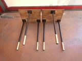 four baseball bats sitting on top of a wooden stand
