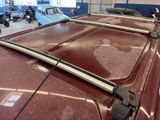 a red car with a roof rack on it in a garage