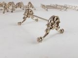 a lot of silver jewelry on a white surface