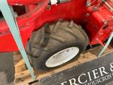 a red tractor with a big tire on a pallet