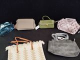 several purses are lined up on a table with a black background