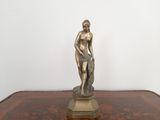une statue représentant un homme assis sur une table en bois