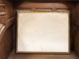 a picture frame in the corner of a wooden cabinet