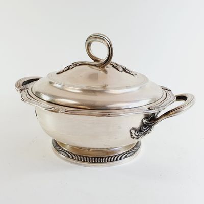an antique silverplated casserole with a lid and handles