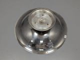 a silver plate with a metal lid on a table