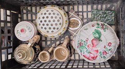 de nombreuses assiettes et bols dans un panier en métal posé sur l'étagère