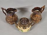 three pieces of antique silverware on a white table cloth
