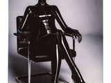 lady in black latex sitting in a chair with her legs crossed