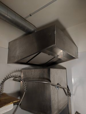 une cuisinière en acier inoxydable dans une cuisine, à côté d'un évier