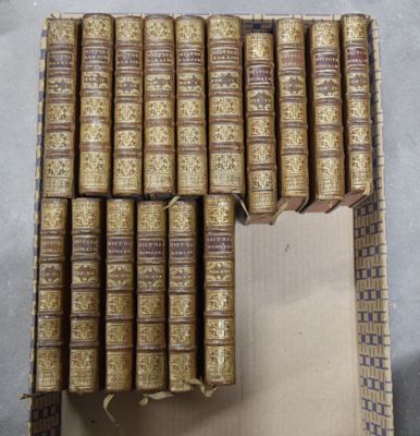 plusieurs vieux livres empilés les uns sur les autres dans une boîte en carton