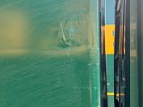 a green train that is parked next to another train